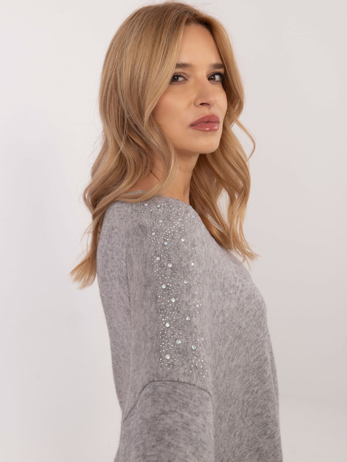 Elegantni siv pulover z aplikacijo