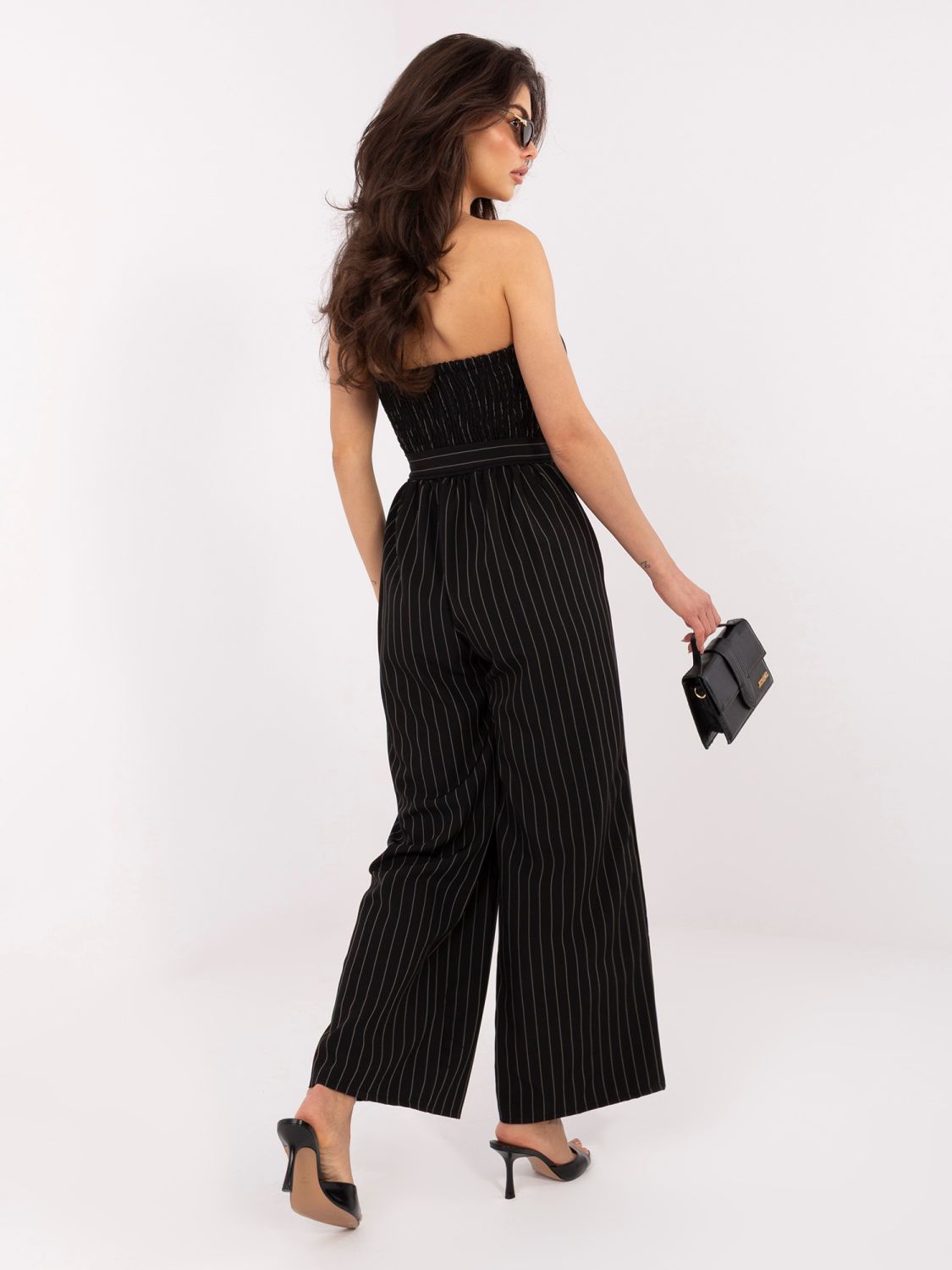 Črn črtast kombinezon s pasom in širokimi hlačnicami